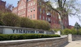 QU Sign and Francis Hall in Spring, West View